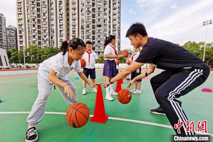 老师指导学生学习打篮球。　彭俊 摄